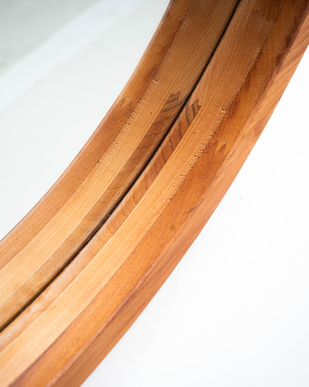 Imagen detallada del marco del espejo circular de dos capas en madera de raulí. Refleja un diseño elegante y natural.