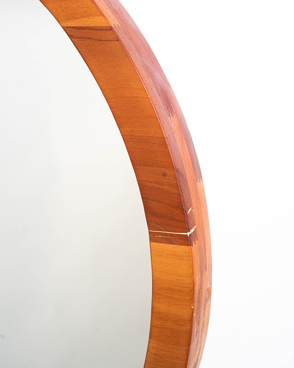 Imagen detallada del marco del espejo circular de tres capas raulí en madera de raulí.  Refleja su diseño robusto y natural.