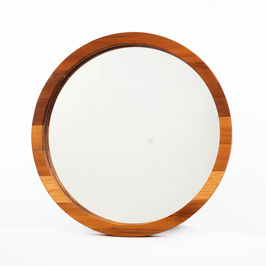 Espejo circular de dos capas en madera de raulí, situado sobre un fondo blanco, que resalta su estética minimalista y natural. 