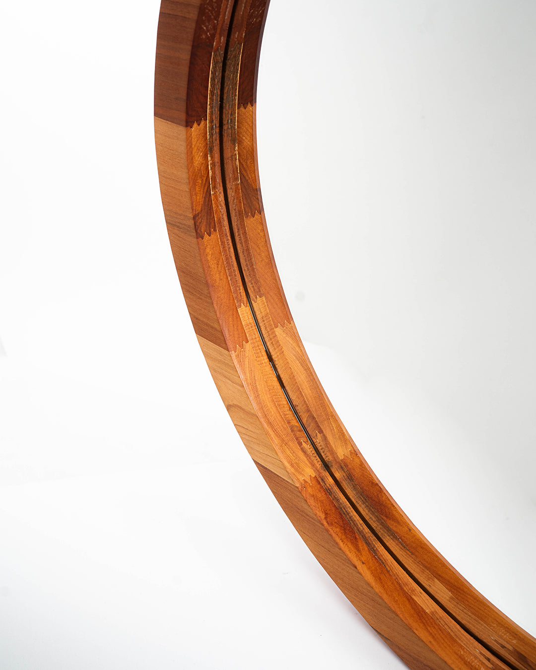 Imagen detallada del espejo circular de dos capas en madera de raulí. Muestra los tonos de la madera y la buena terminación del producto.