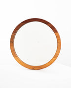 Espejo circular de una capa en madera de raulí, situado sobre un fondo blanco, que resalta su estética minimalista y natural.