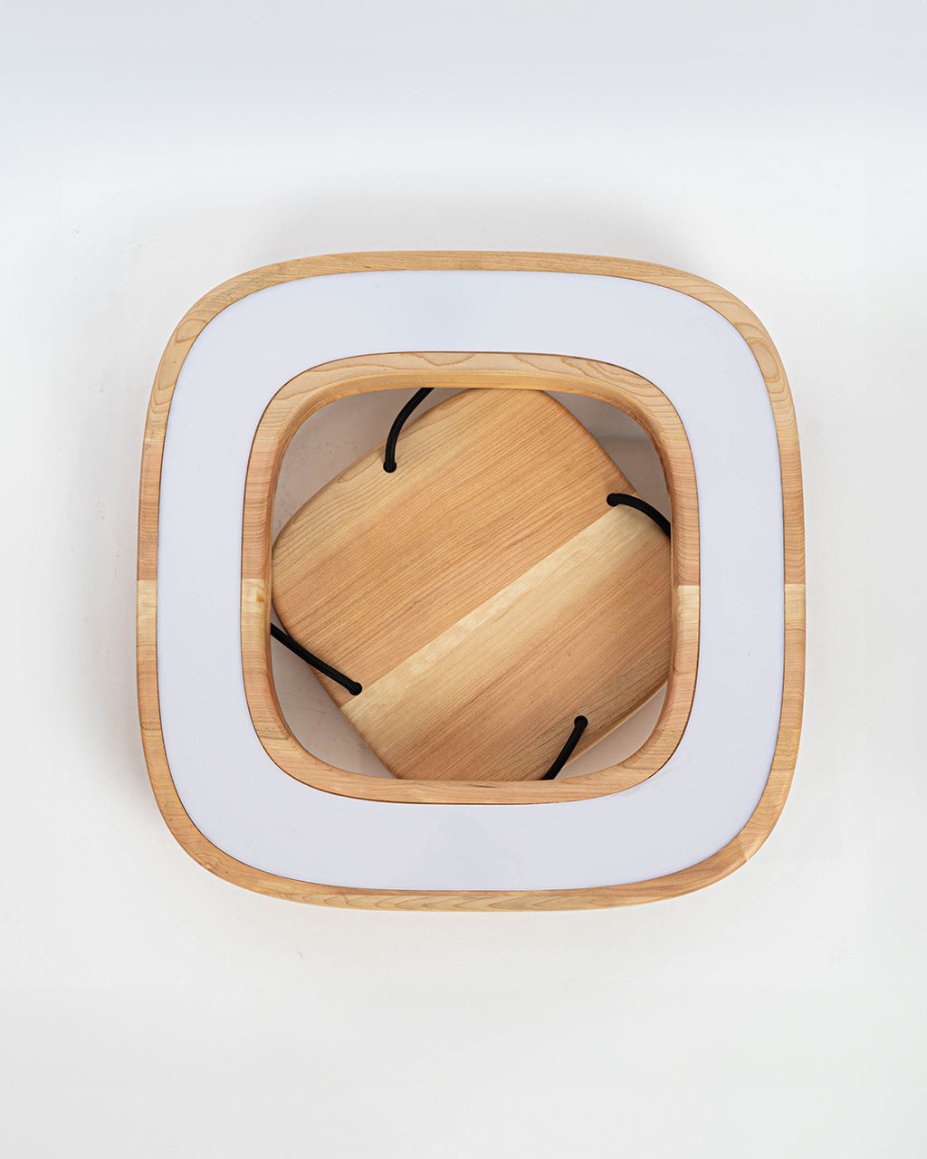 Imagen inferior de lámpara de techo quadrat en madera de lenga. Se aprecia su forma cuadrada con bordes redondeados y su pantalla blanca para difuminar la iluminación LEDs.